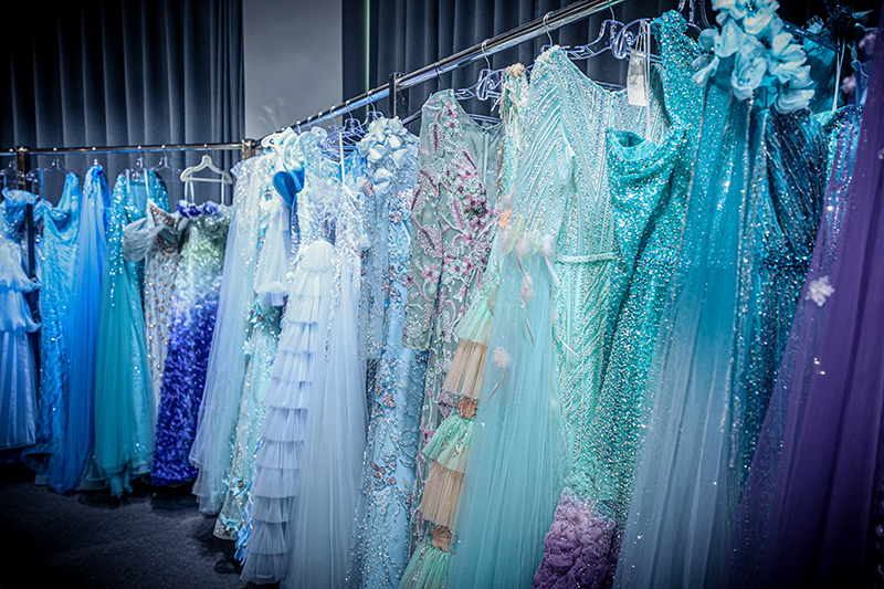 Fileiras de vestidos finalizados pendurados em varões